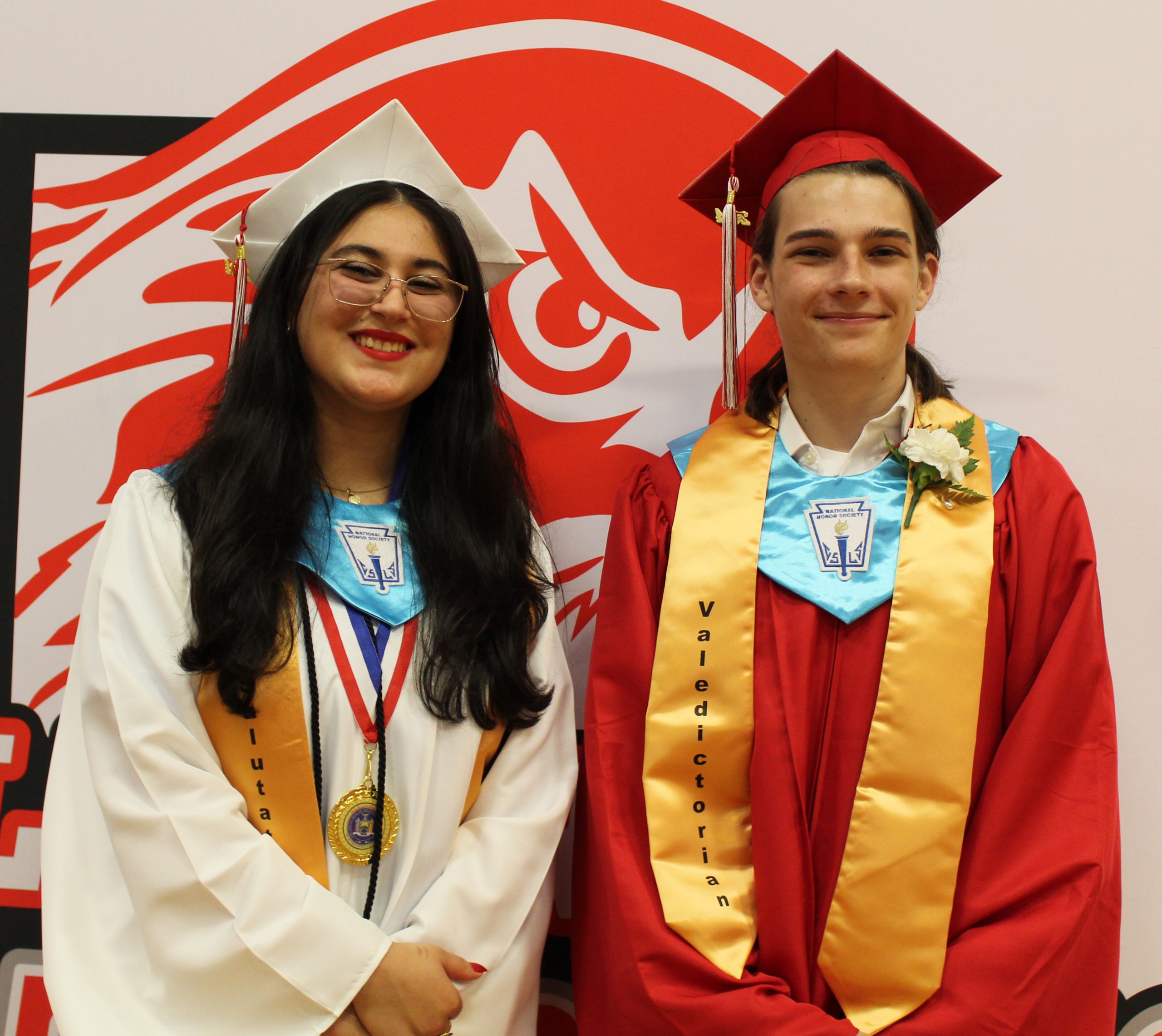 The valedictorian and salutatorian pose for a photo in front of the liberty logo.
