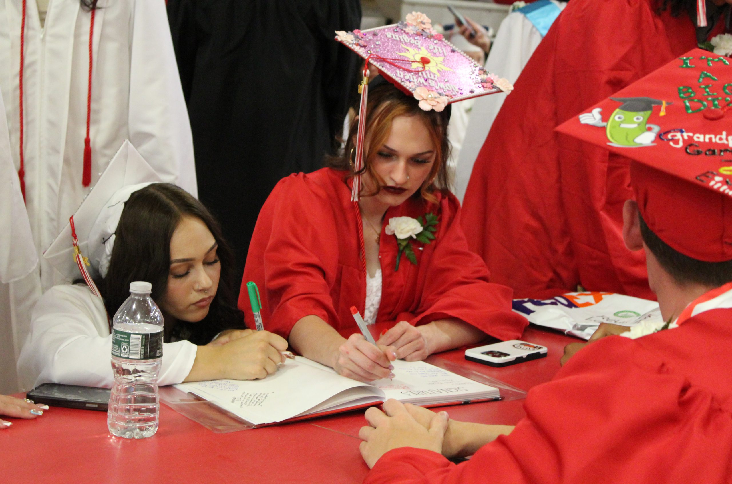 Two students sign a yearbook