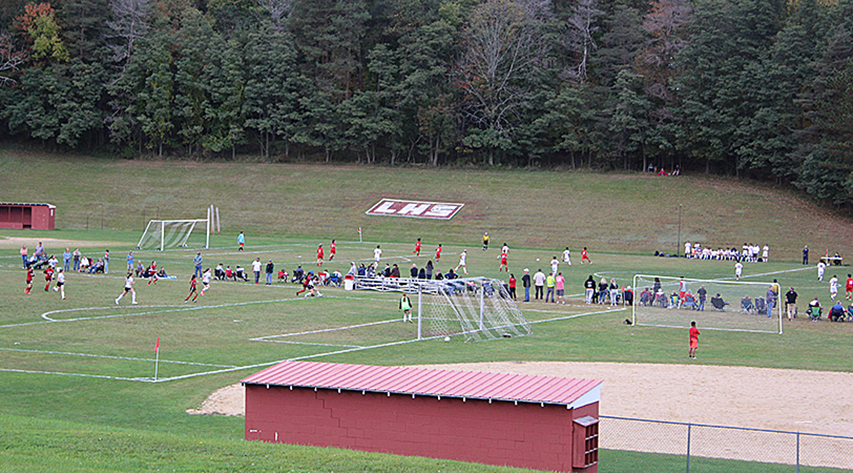 Two soccer games are played on neighboring fields with the softball field in the right foreground and the LHS sign on the hill behind the fields