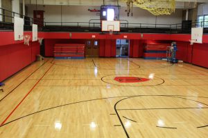 An empty gymnasium with elevated seating around the edge