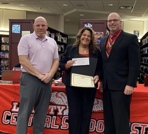 A woman holding a certificate and a paper stands between two men